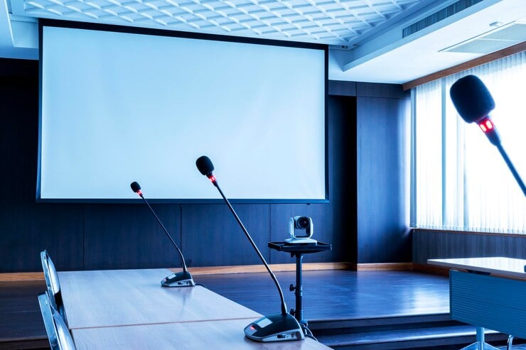 microphone-table-with-projector-screen-background-meeting-room_281691-2698